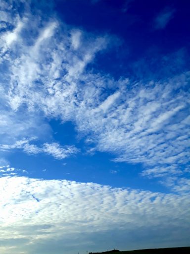 Heller blauer Himmel mit weißen, wolkenartigen Strukturen.
